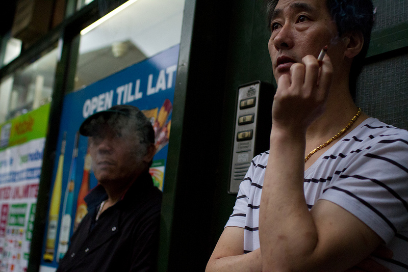 two asian men having a lunch break and smoking, central london area